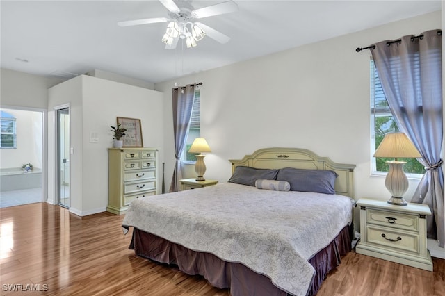 bedroom featuring ceiling fan, ensuite bath, and hardwood / wood-style flooring