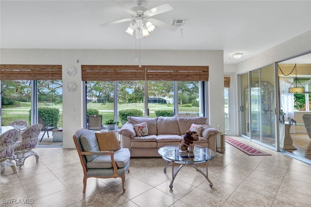 tiled living room featuring ceiling fan and plenty of natural light