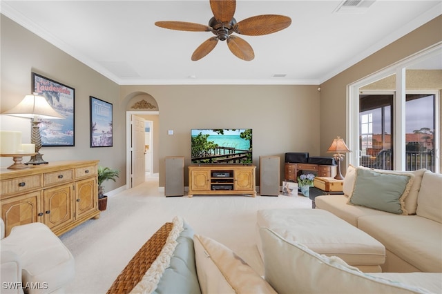 living area featuring light carpet, ceiling fan, visible vents, and ornamental molding