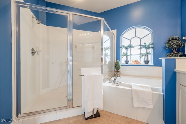 bathroom with a stall shower, tile patterned flooring, and a garden tub