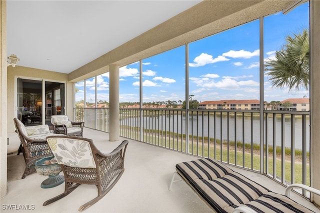 sunroom featuring a water view