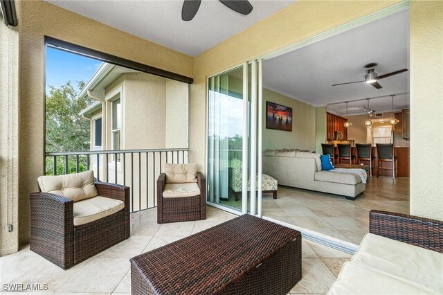 balcony featuring ceiling fan, a sunroom, and an outdoor living space