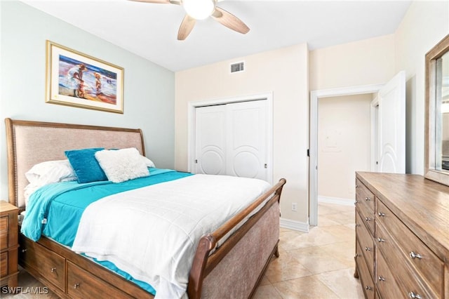 bedroom with a closet, visible vents, light tile patterned flooring, ceiling fan, and baseboards