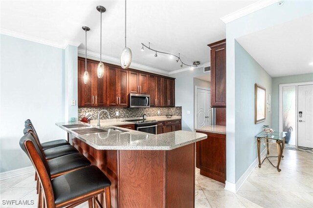 kitchen featuring stainless steel appliances, decorative light fixtures, kitchen peninsula, decorative backsplash, and light stone countertops