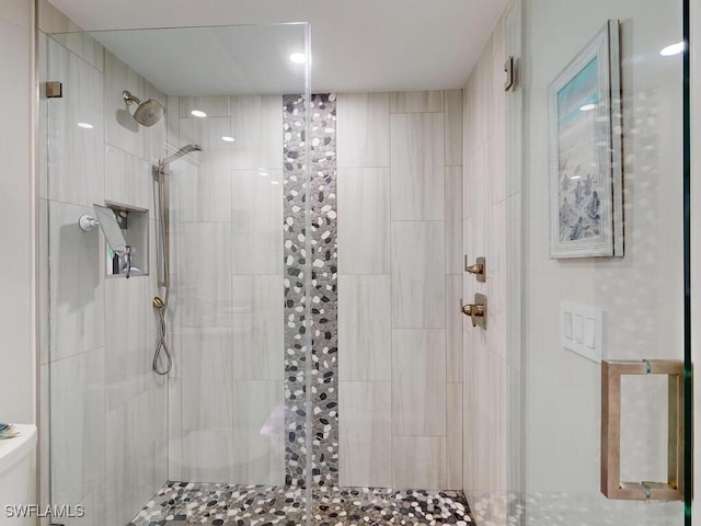 bathroom featuring an enclosed shower and toilet