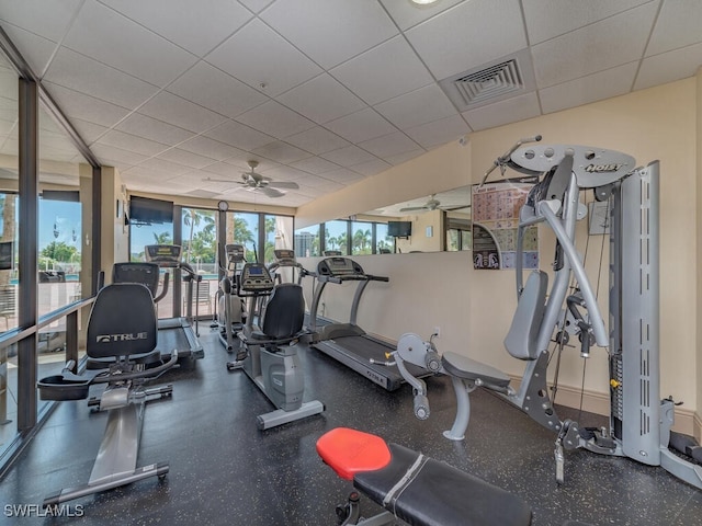 exercise room featuring ceiling fan and a drop ceiling