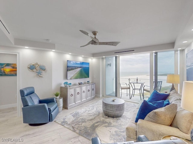 living room with ceiling fan and light hardwood / wood-style flooring