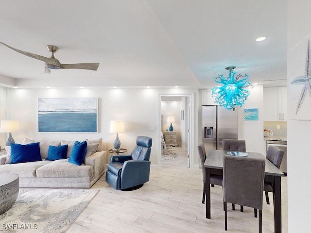 living room with ceiling fan and light hardwood / wood-style flooring