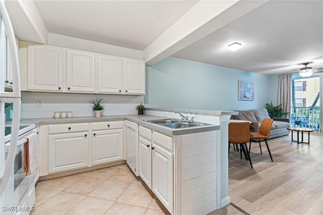 kitchen with white appliances, white cabinets, sink, kitchen peninsula, and ceiling fan