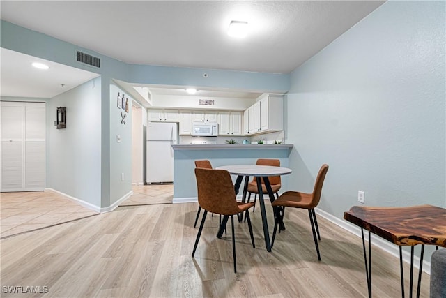 dining area with light hardwood / wood-style flooring