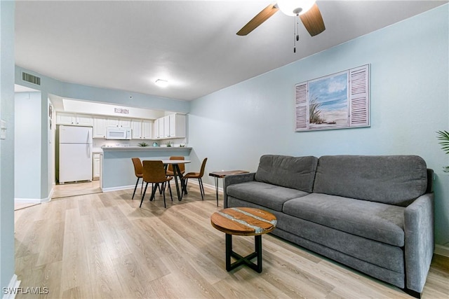 living room featuring ceiling fan and light hardwood / wood-style flooring