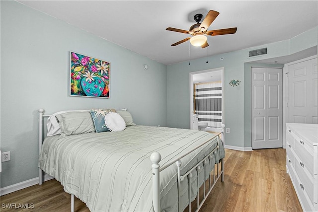 bedroom featuring light wood-type flooring, ensuite bathroom, a closet, and ceiling fan