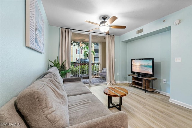 living room featuring a wall of windows, ceiling fan, and light hardwood / wood-style flooring