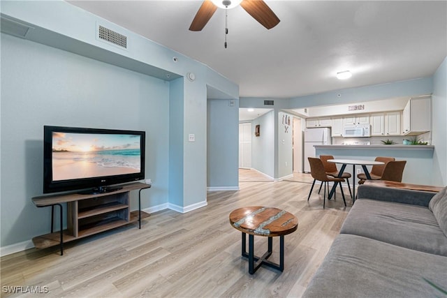 living room featuring light hardwood / wood-style floors and ceiling fan