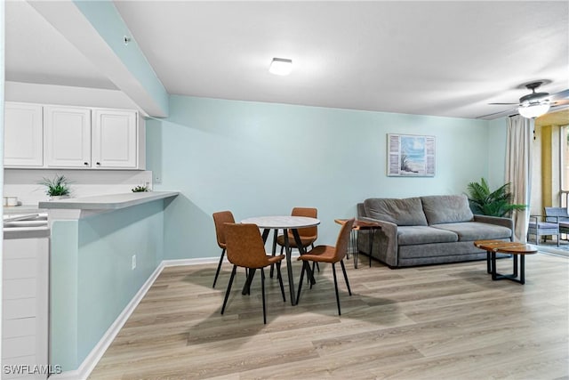 dining area with ceiling fan and light hardwood / wood-style flooring