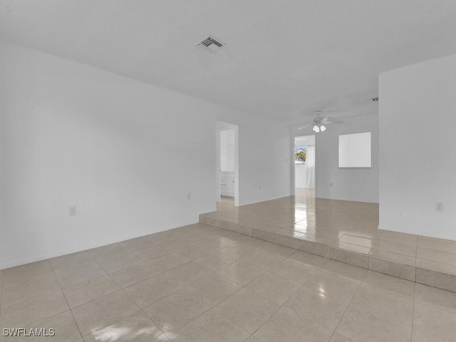 tiled empty room featuring ceiling fan