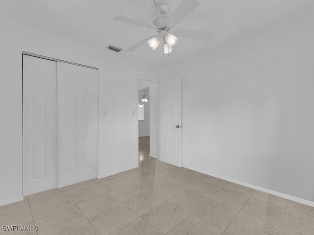 unfurnished bedroom featuring a closet, light tile patterned floors, and ceiling fan