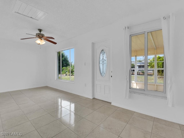 foyer featuring ceiling fan, a textured ceiling, and light tile patterned flooring