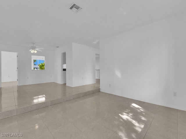 tiled spare room with ceiling fan