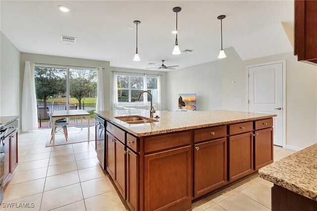 kitchen featuring pendant lighting, dishwasher, sink, light tile patterned flooring, and an island with sink