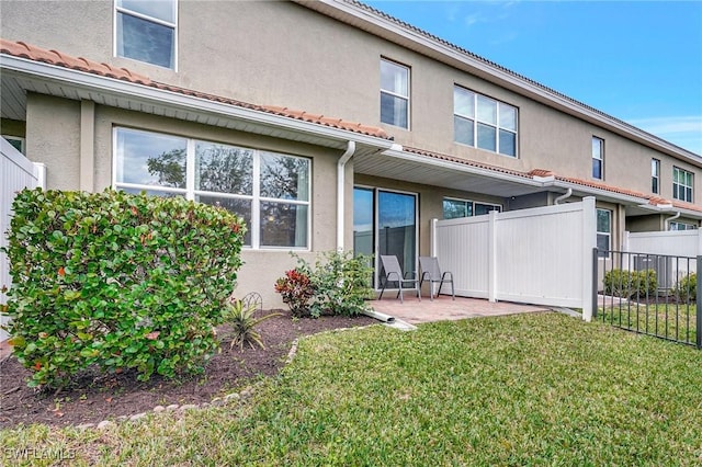 back of property with a patio and a yard