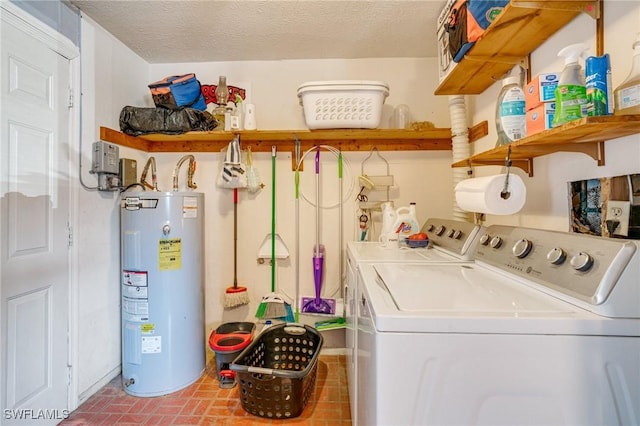 laundry area featuring washing machine and dryer, water heater, and a textured ceiling