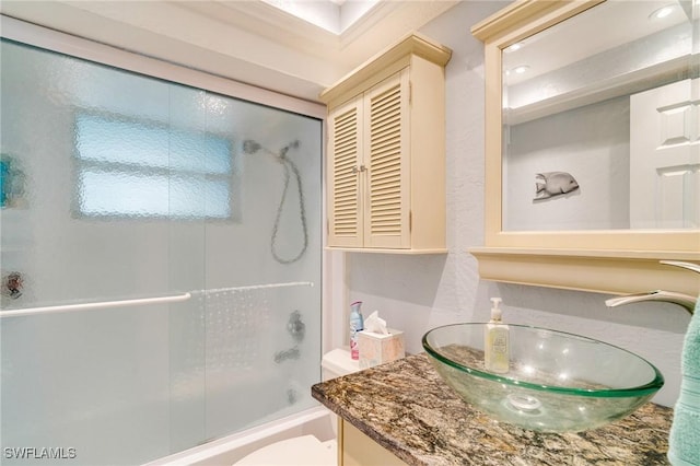 full bathroom with toilet, bath / shower combo with glass door, and vanity