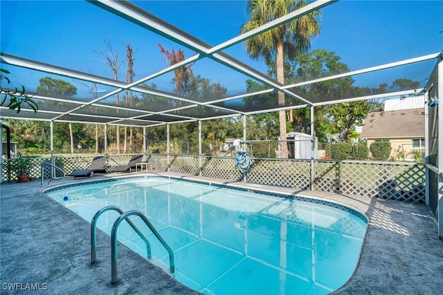 view of pool featuring a lanai and a shed