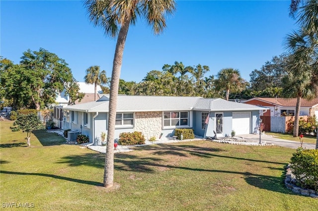 single story home featuring a garage, cooling unit, and a front lawn