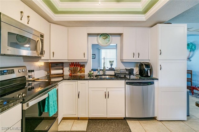 kitchen with sink, stainless steel appliances, a raised ceiling, and white cabinetry