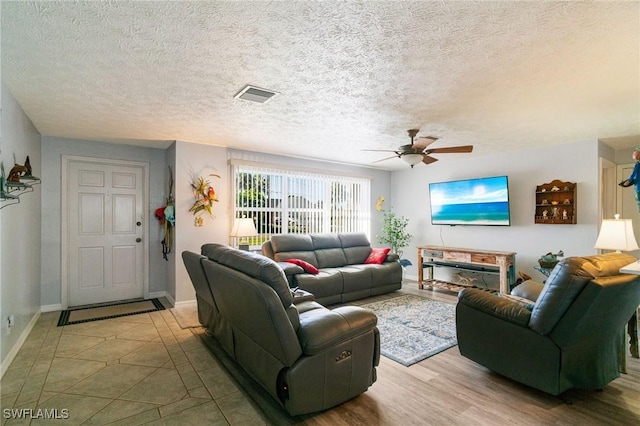 living room with ceiling fan and a textured ceiling