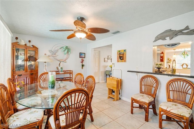 tiled dining area featuring ceiling fan and a textured ceiling