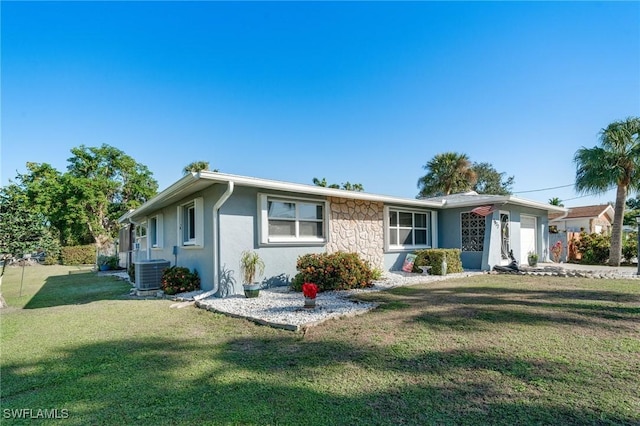 single story home featuring central air condition unit, a front yard, and a garage