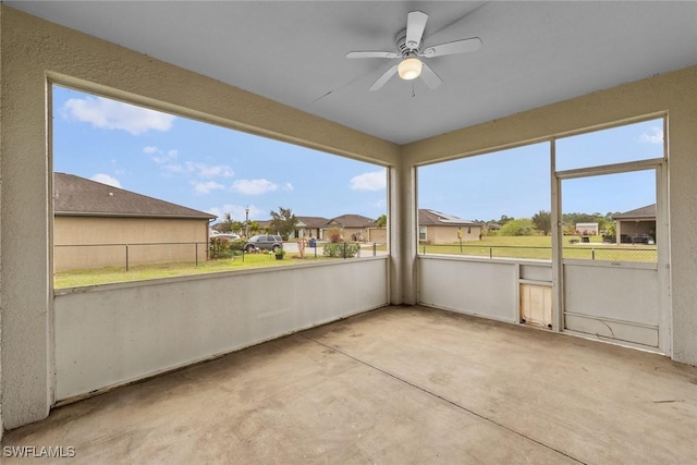 unfurnished sunroom featuring ceiling fan