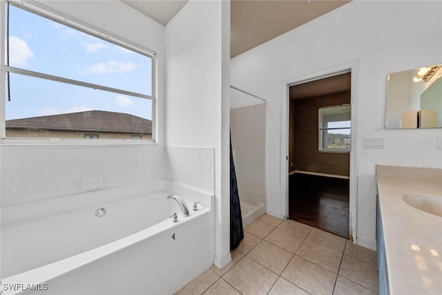 bathroom featuring vanity, tile patterned floors, plus walk in shower, and plenty of natural light