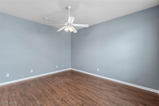 unfurnished room featuring ceiling fan and dark wood-type flooring