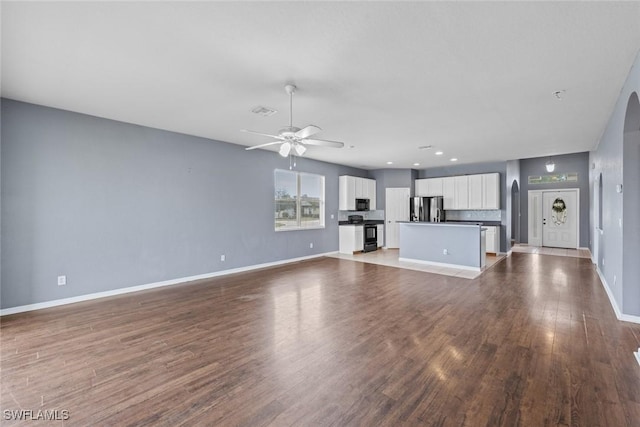 unfurnished living room featuring ceiling fan and wood-type flooring