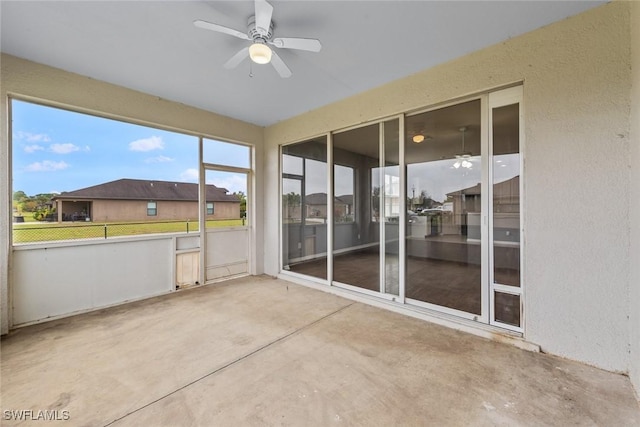 unfurnished sunroom featuring ceiling fan