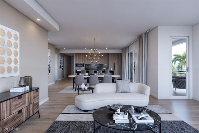 living room with an inviting chandelier and light hardwood / wood-style floors