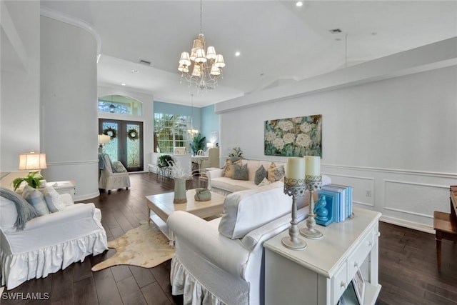 living room featuring a chandelier, dark wood-style flooring, wainscoting, and a decorative wall