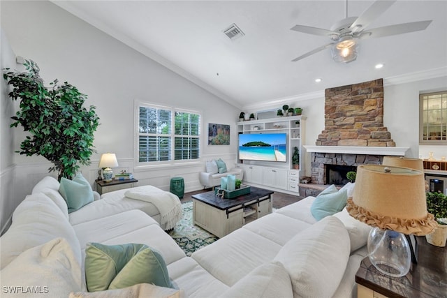 living area featuring a wainscoted wall, a fireplace, lofted ceiling, visible vents, and ornamental molding