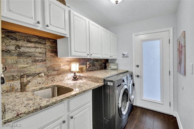 laundry area with dark wood-type flooring, a sink, baseboards, independent washer and dryer, and cabinet space