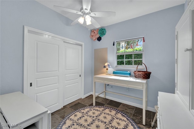 office area featuring a ceiling fan and baseboards