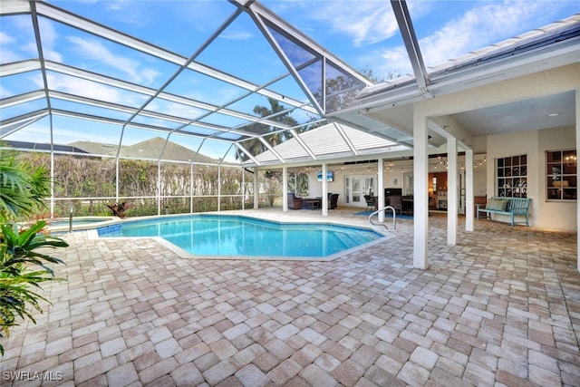 view of swimming pool featuring a patio, ceiling fan, a lanai, french doors, and a pool with connected hot tub