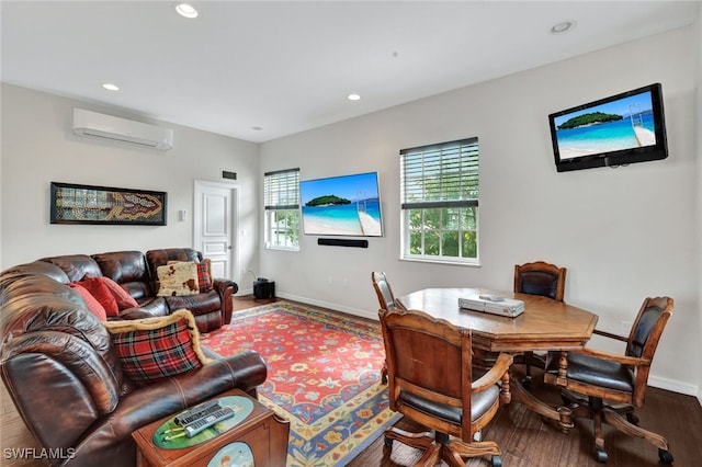 living room featuring recessed lighting, a wall unit AC, wood finished floors, and baseboards