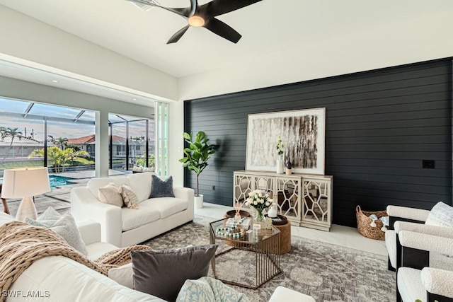 living room featuring wood walls and ceiling fan