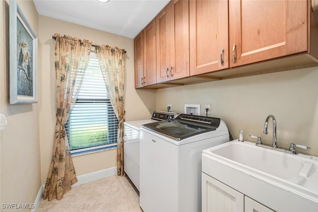 washroom featuring cabinets, light tile patterned flooring, washer and clothes dryer, and sink