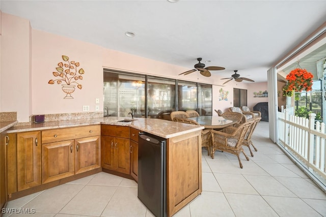 kitchen featuring dishwasher, sink, ceiling fan, light tile patterned floors, and kitchen peninsula