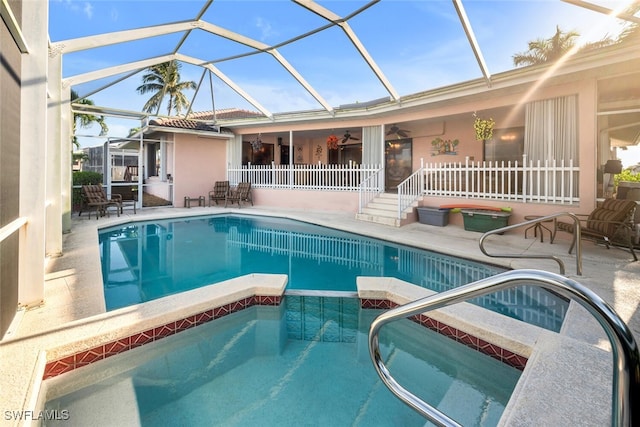 view of swimming pool featuring a lanai, a patio area, and ceiling fan