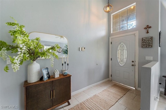 entryway featuring light tile patterned flooring and a high ceiling